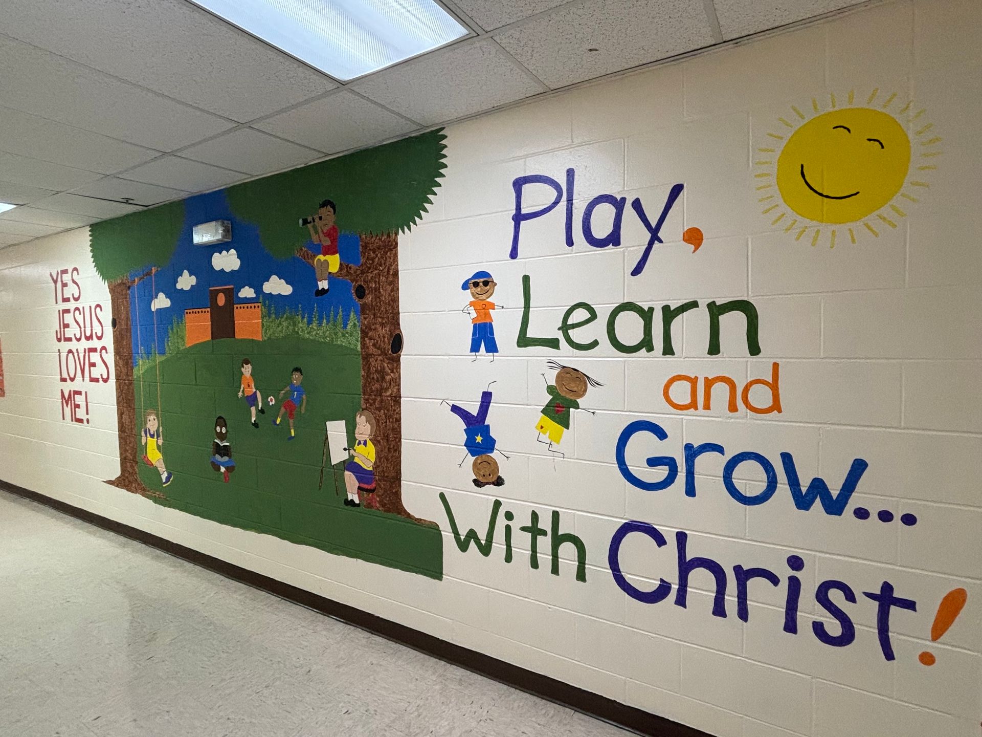 A hallway with a mural that says play learn and grow with christ