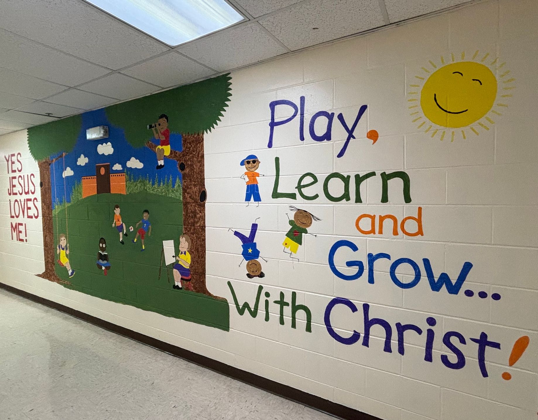 A mural on a wall that says play learn and grow with christ