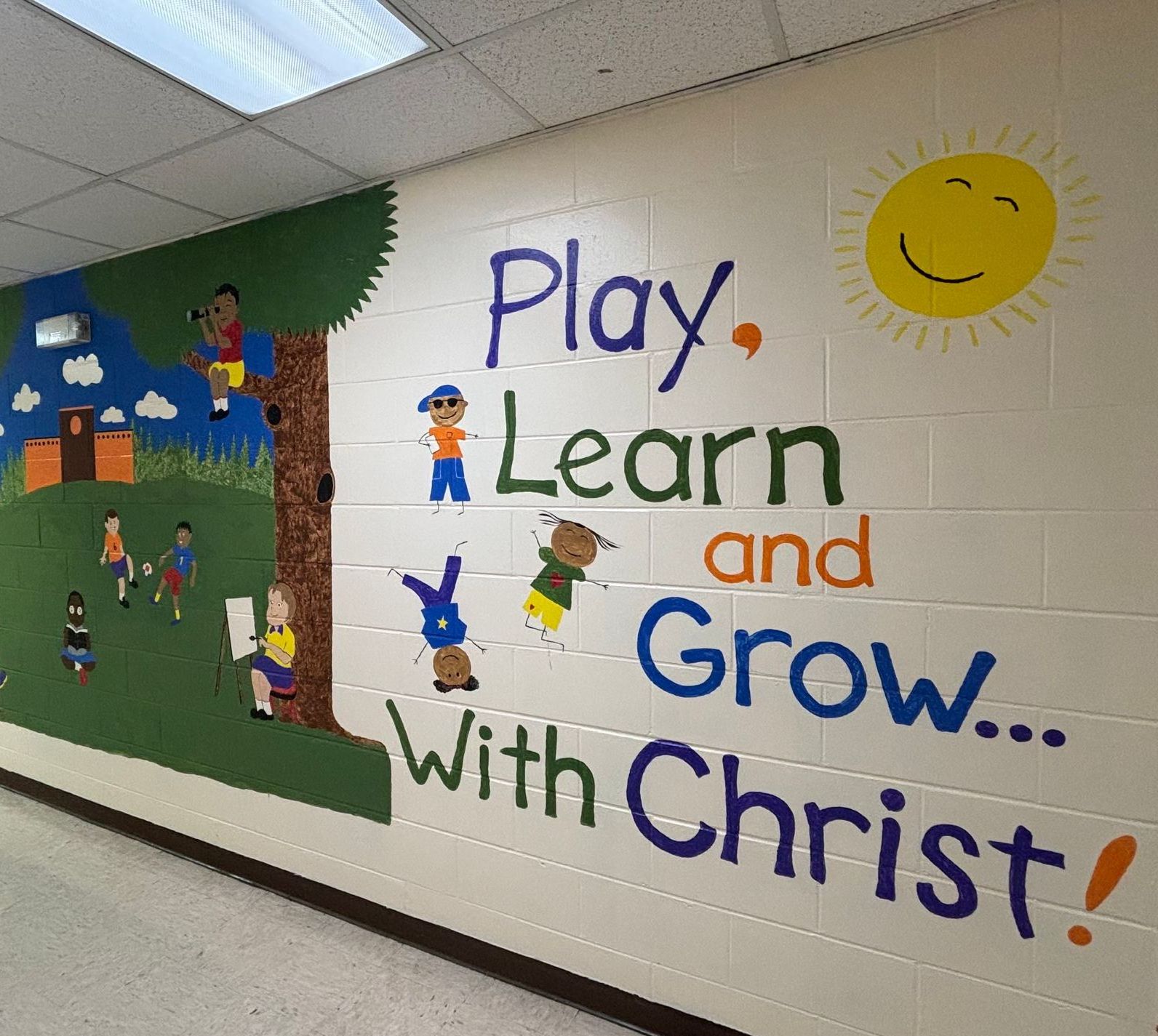 A mural on a wall that says play learn and grow with christ