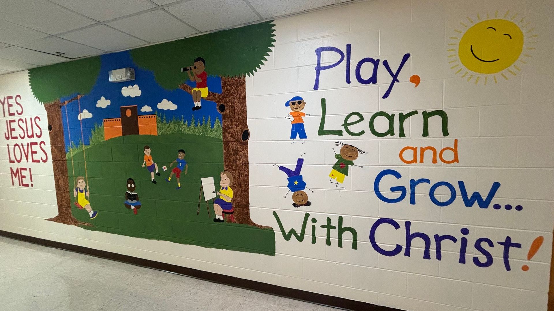 A mural on a wall that says play learn and grow with christ