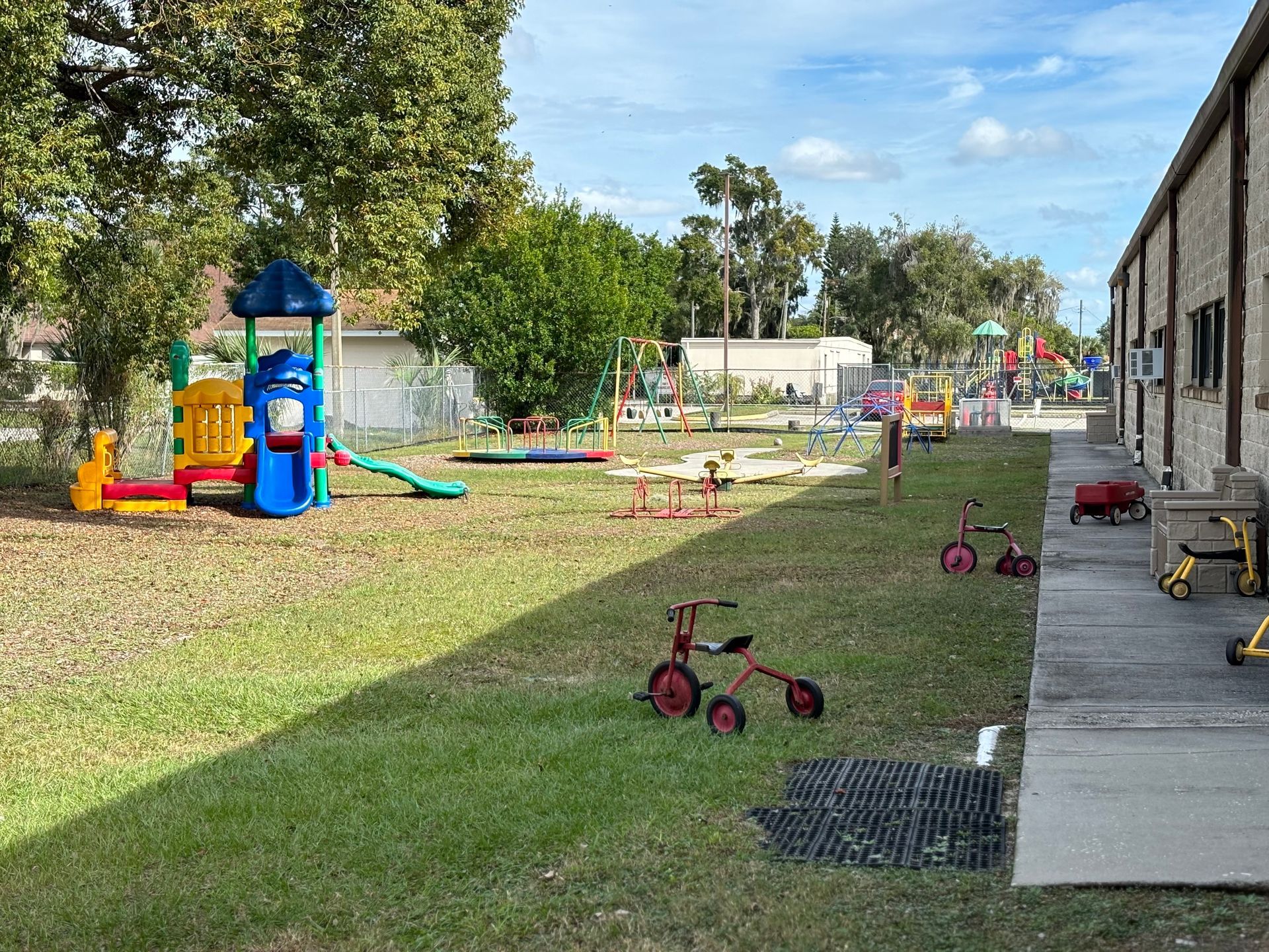 There is a playground in the backyard of a building.