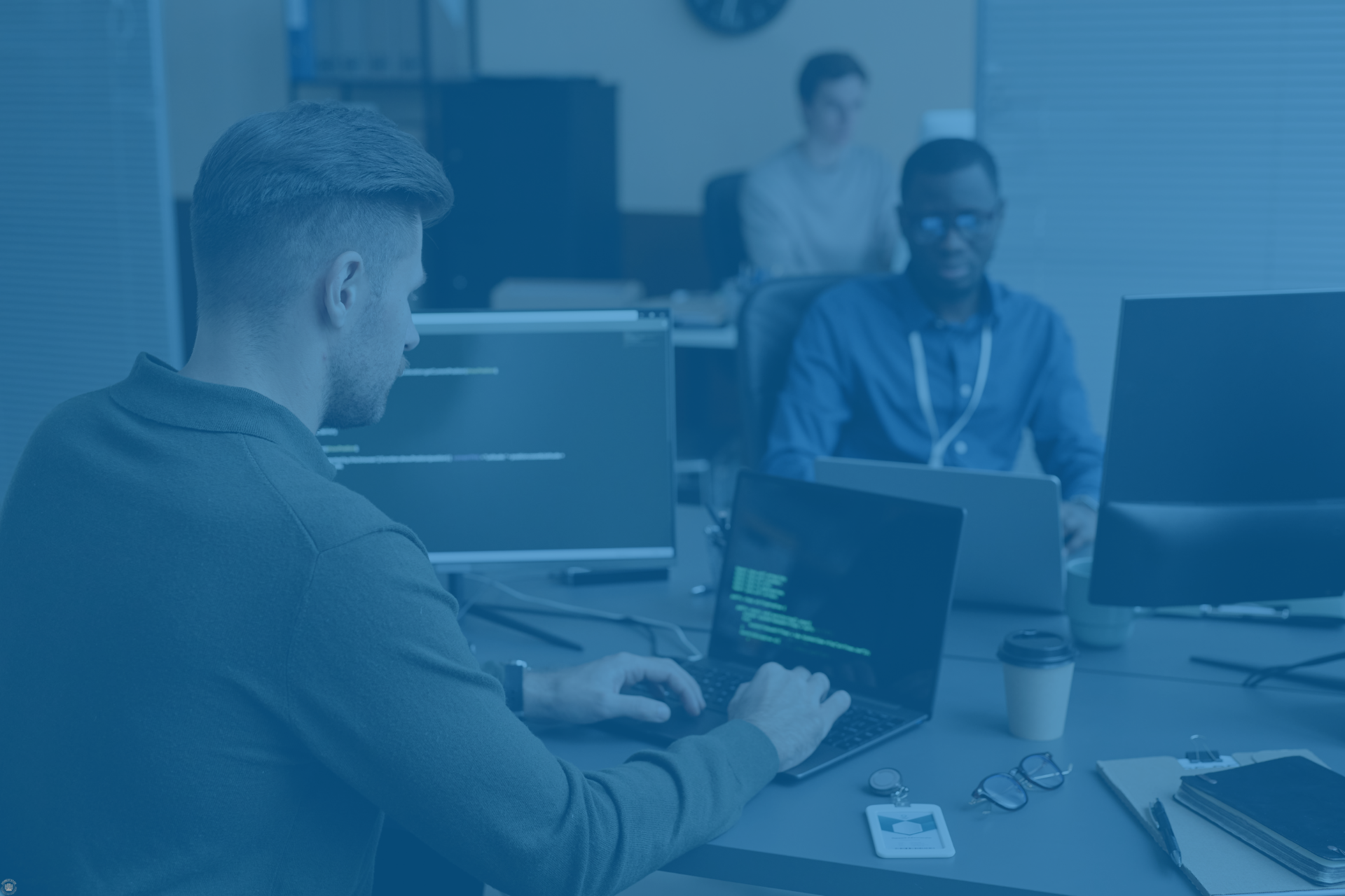 Tech professionals working on devices, representing cloud, cybersecurity, and AI solutions.
