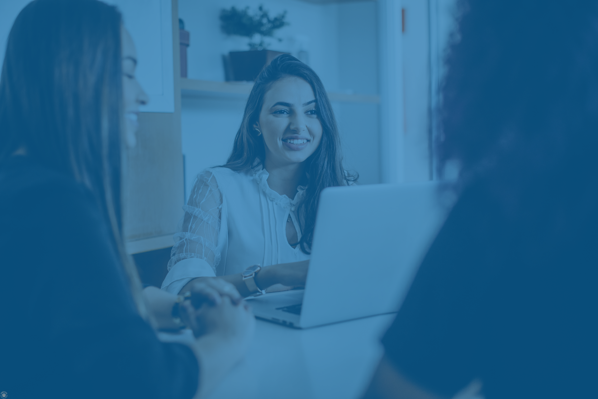 Professionals meeting around a laptop, representing marketing collaboration and co-selling support.