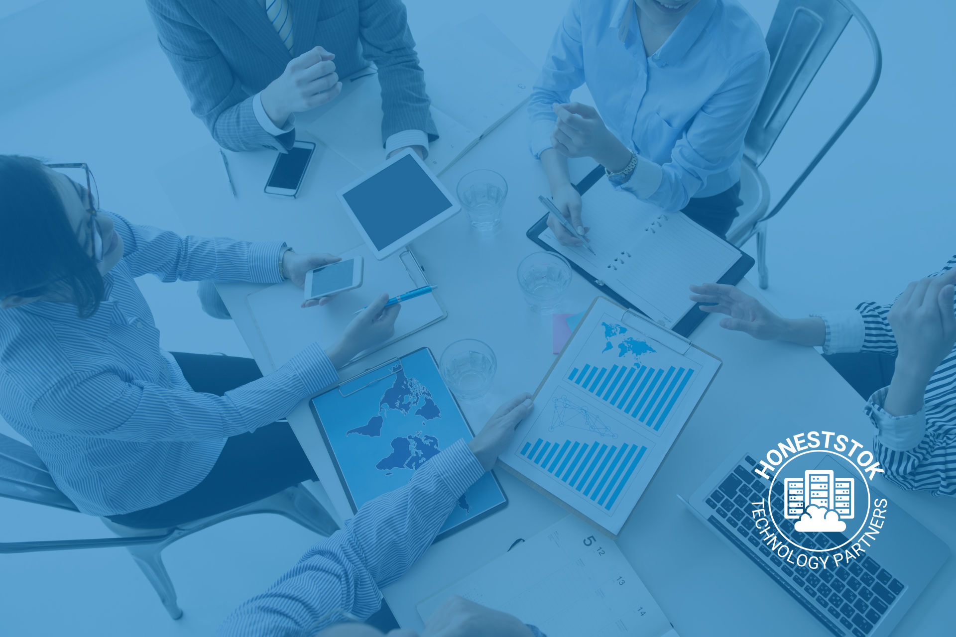 Business professionals reviewing technology distributor data, charts, and devices.