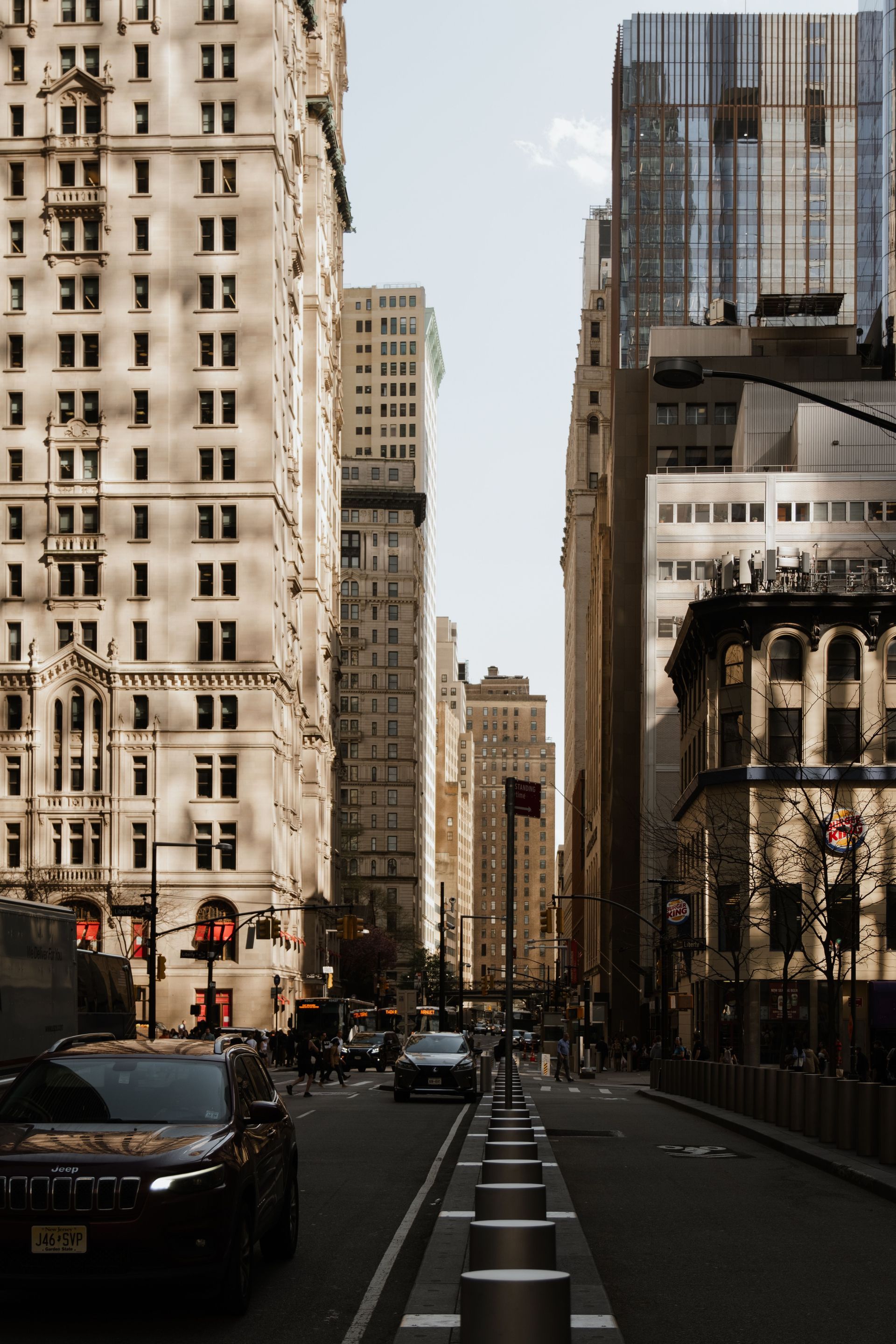 City street with tall buildings, cars, and a bike lane in an urban downtown area