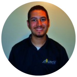 Smiling man in a dark shirt against a light green background