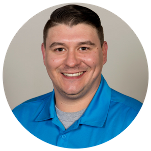 Smiling person in a bright blue collared shirt on a light gray background