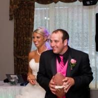 Bride and groom sitting together, smiling at a formal indoor celebration