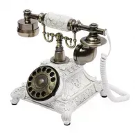 Vintage white rotary telephone with ornate base and black dial on a white background