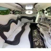 White stretch limousine interior with black trim and plush bench seating