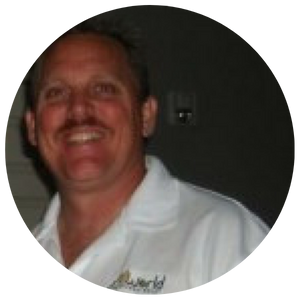Smiling man in a white collared shirt against a dark background