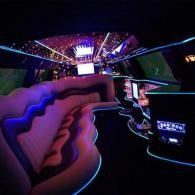 Neon-lit lounge with pink curved seating and glowing blue-purple accents