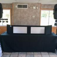 Black-draped table with two white panels in an indoor room