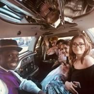 Group smiling inside a decorated limo, taking a selfie while seated close together