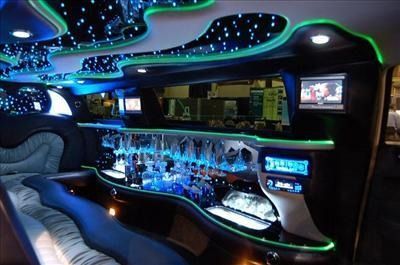 Limousine futuristic neon-lit bar interior with curved seating, blue lighting, and a glossy countertop