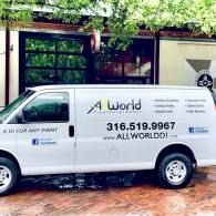 White delivery van with AllWorld logo parked outside a building, with phone number on the side.