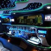 Futuristic bar interior with blue and green neon lights, curved counters, and star-like ceiling lights