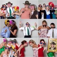 People in costumes posing together at a party photo booth, many holding props and making playful gestures.