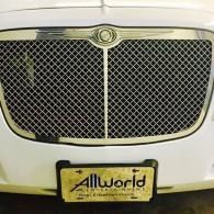 Front view of a white Bentley grille with a gold emblem and AllWorld license plate.