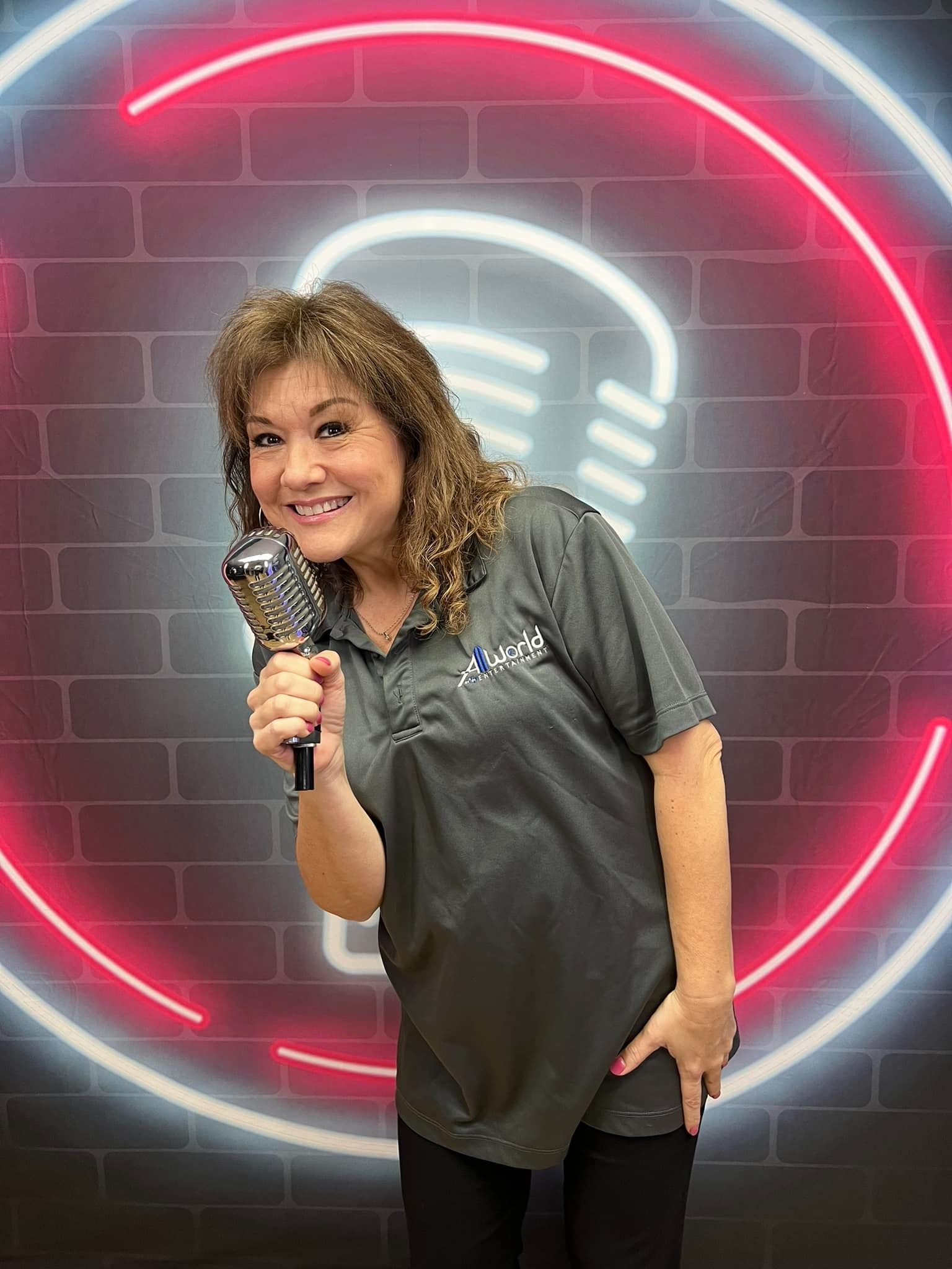 Woman holding a microphone in front of a neon podcast-style backdrop