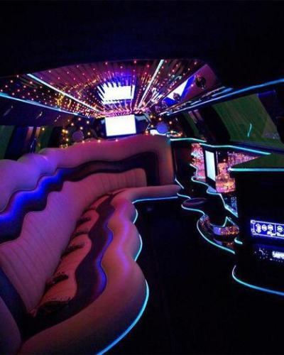 Neon-lit nightclub interior with curved pink seating and colorful ceiling lights in a dark lounge