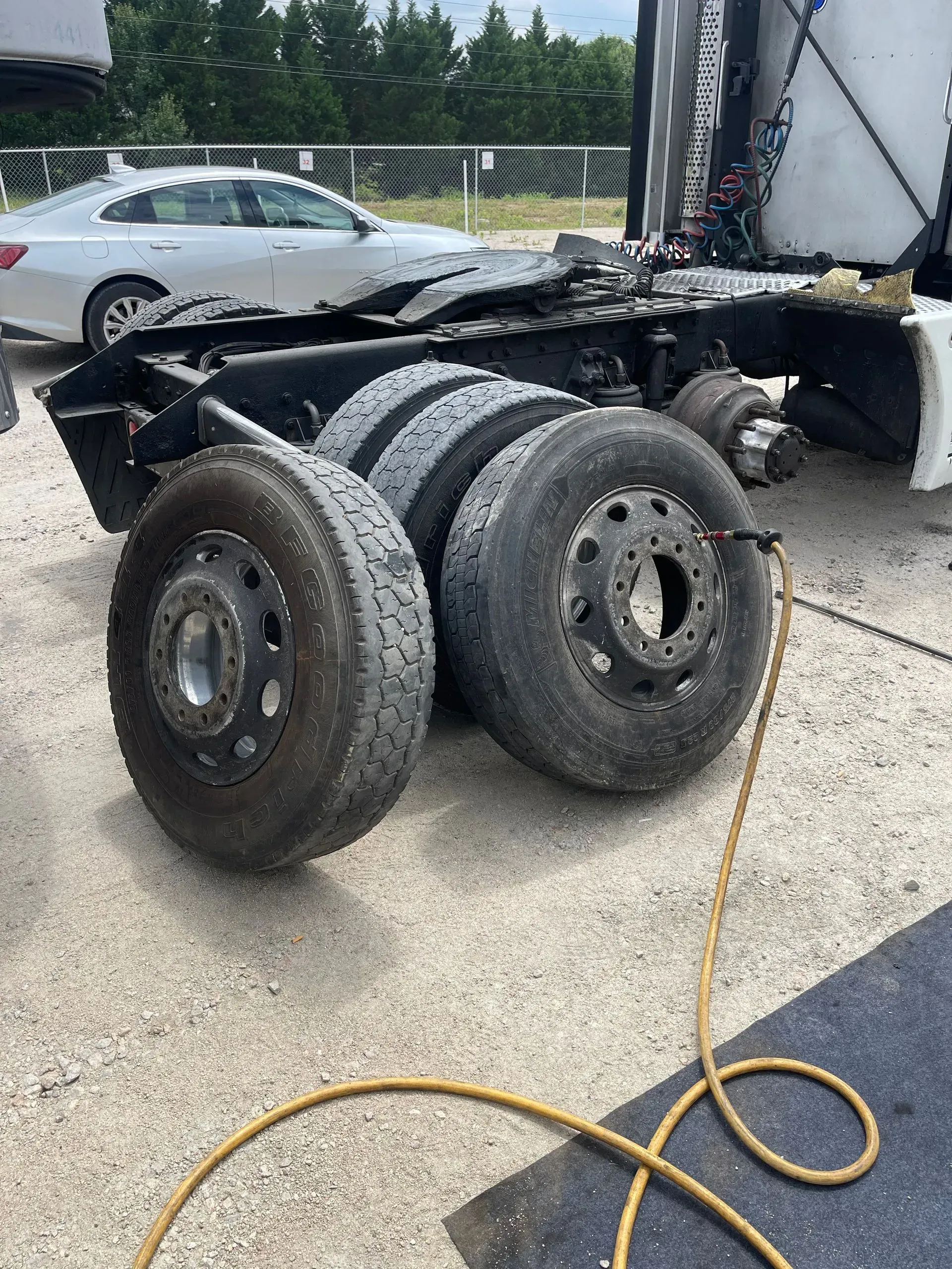 Two tires are sitting on the ground next to a semi truck.