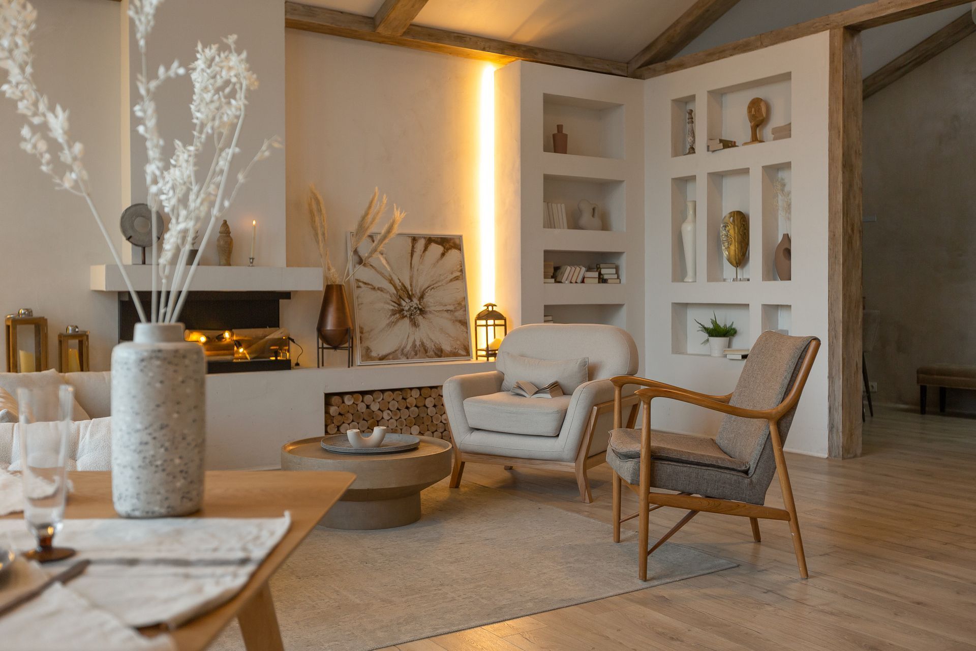 Cozy modern living room with neutral decor, fireplace, wicker chair, and built-in shelves