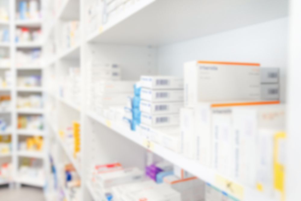 Una imagen borrosa de los estantes de una farmacia llenos de medicamentos.