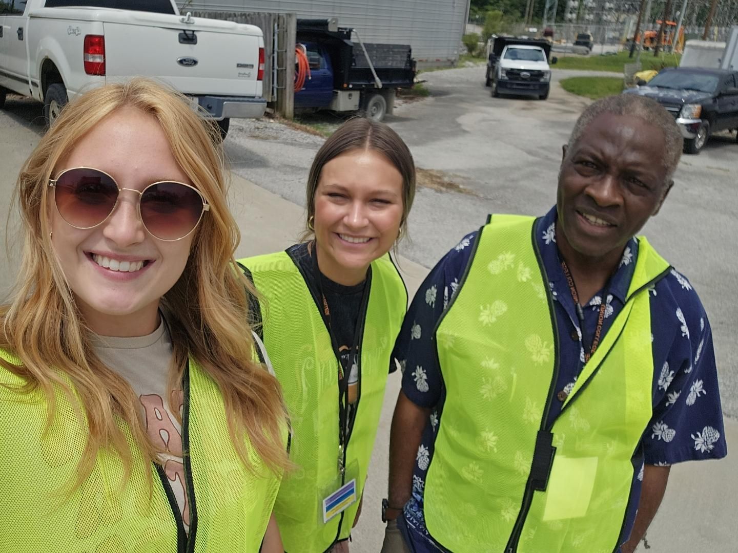 Hannah Baker, Laurel Nolan, and Dr. Fidelis Achenjang wearing yellow safety vests.