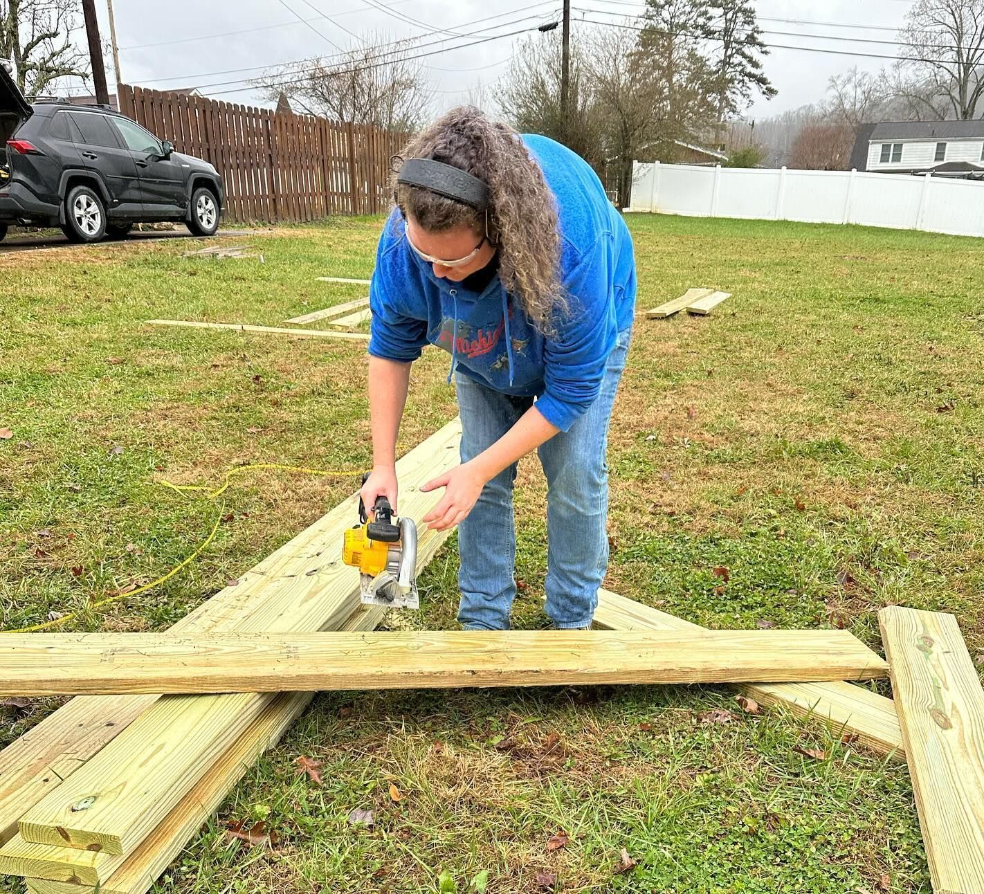 Libby Megna sawing lumber.