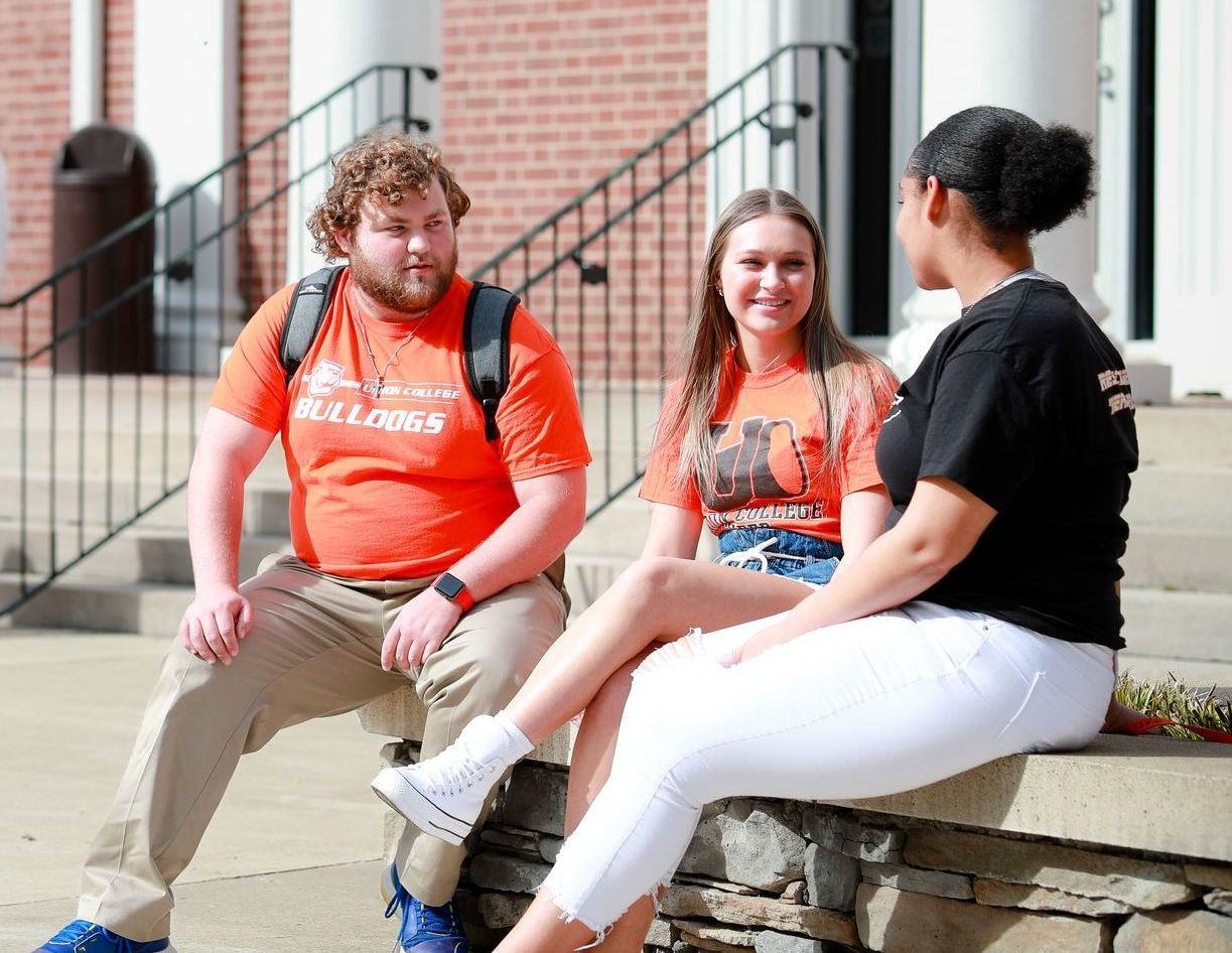 Three Union students conversing in front of the Weeks-Townsend Memorial Library.