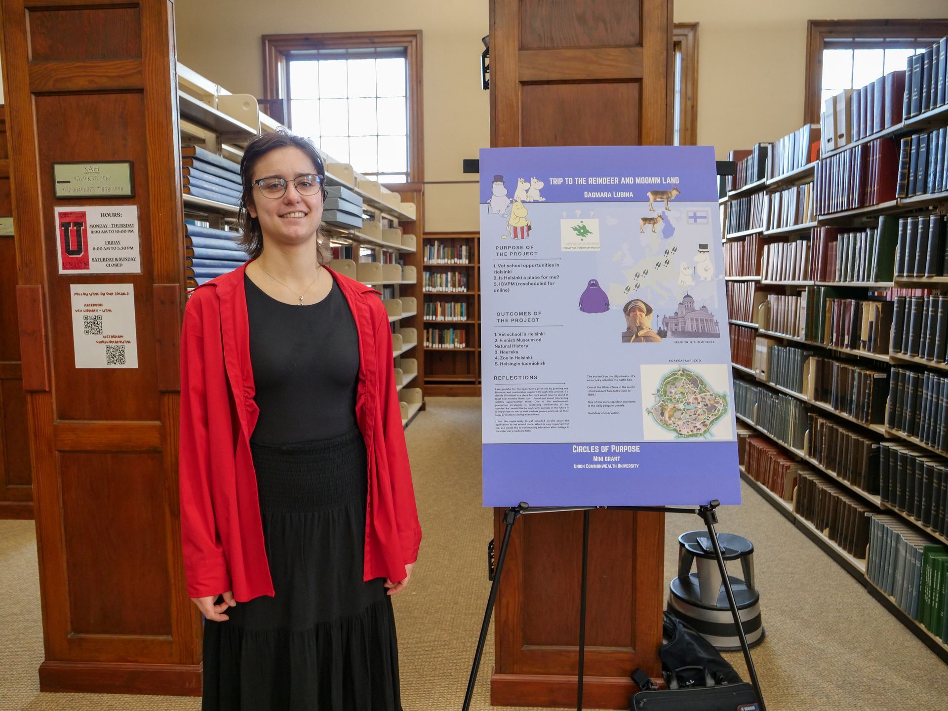 Dagmara Lubina standing by her poster on traveling to Helsinki, Finland and exploring veterinary science.