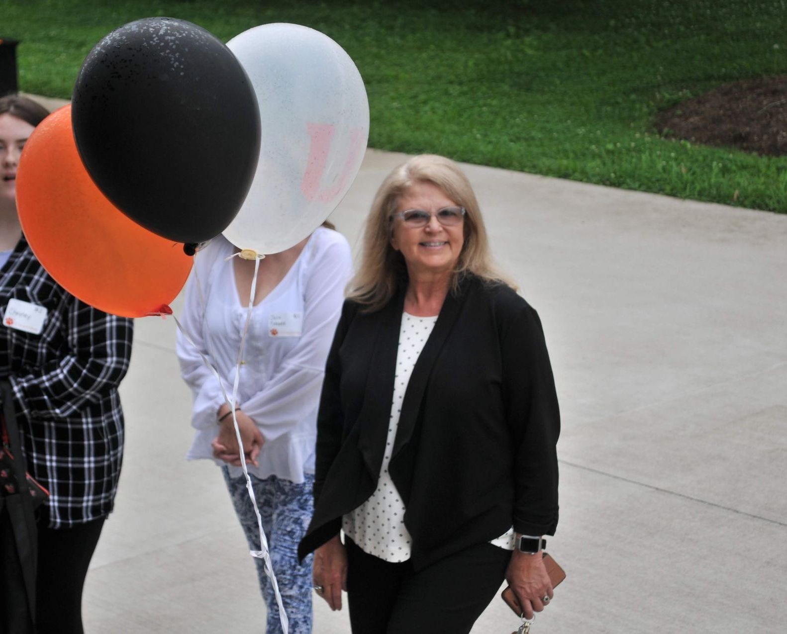 President Dr. Marcia Hawkins smiling with a trio of Union balloons and people beside her.