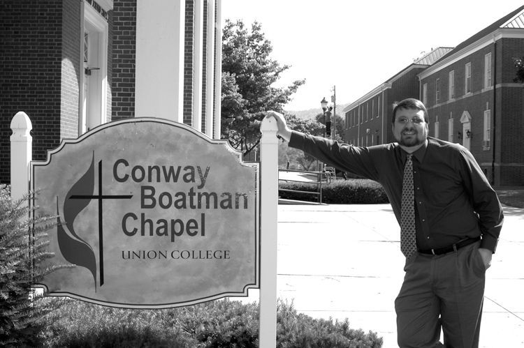 Miller standing next to the sign for Conway Boatman Chapel.