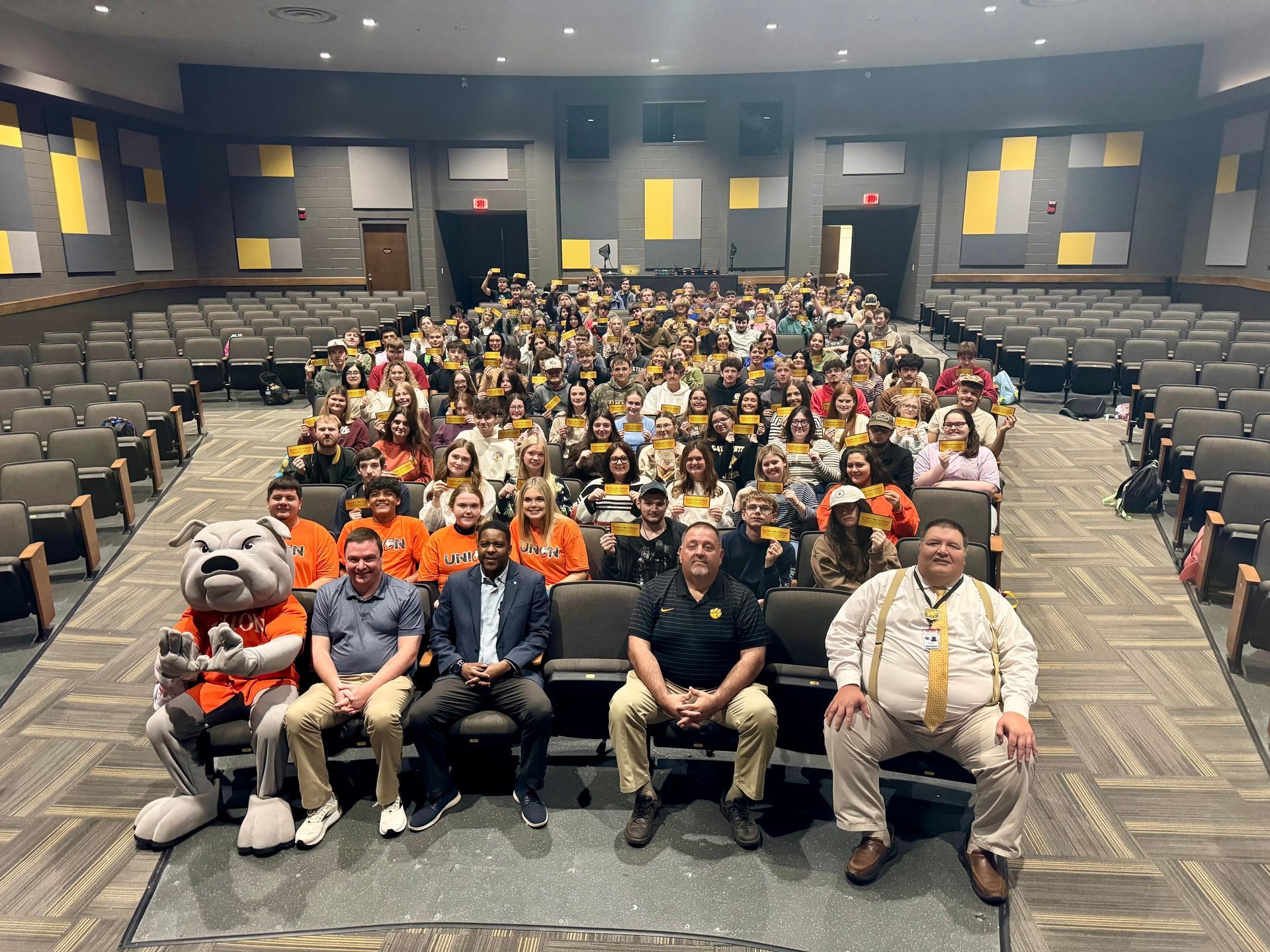 seniors at Clay County High school sitting in auditorium chairs with their golden ticket