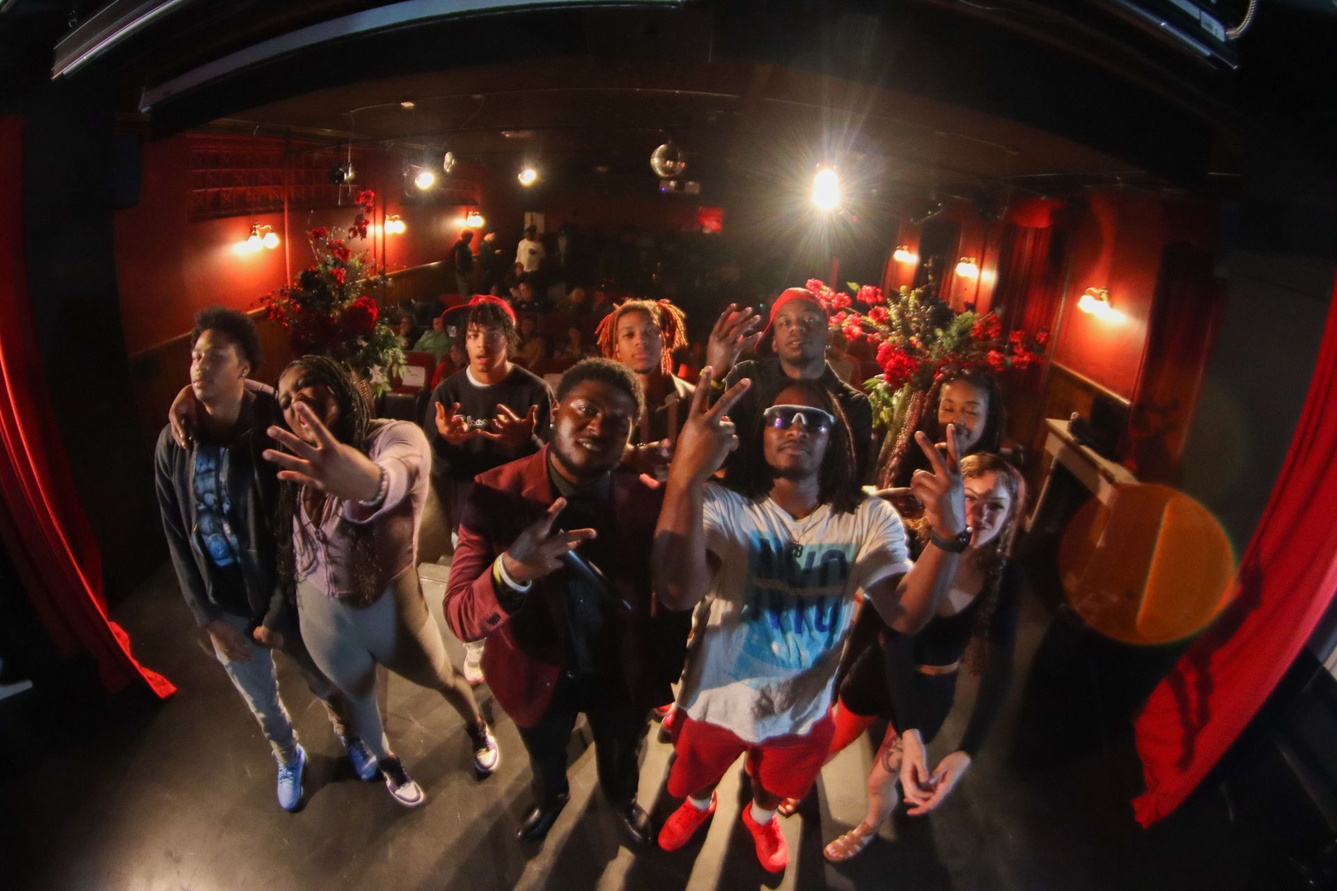 BSU members posing together and throwing up peace signs on stage.