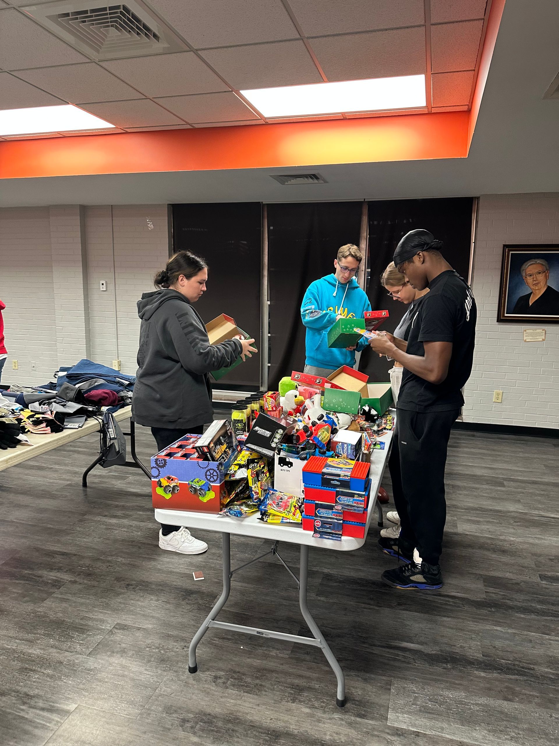 Makynzie Miller and members of the swim team pack toys into gift boxes.