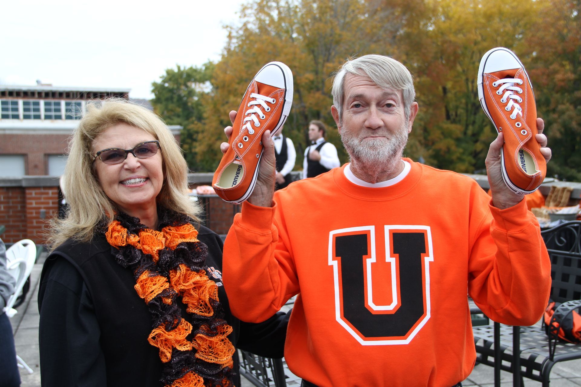 Union President Dr. Marcia Hawkins standing with Martin Williamson who is holding two Union orange shoes.