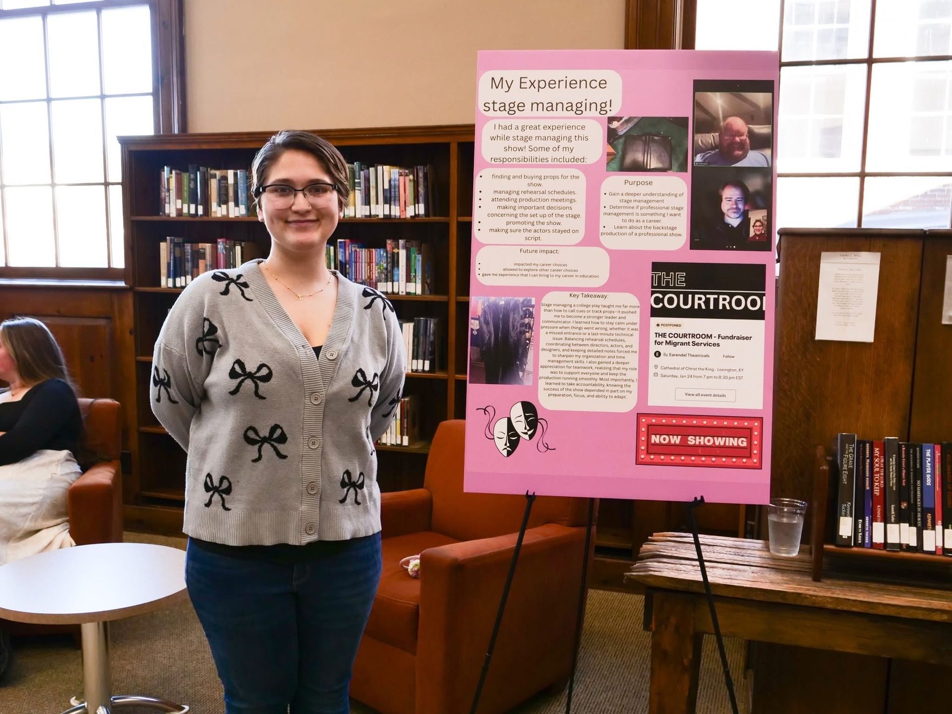 Kaydince Williamson standing with her poster over her experience as a stage manager.