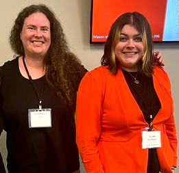 Megna and Tia stand side-by-side wearing conference badges and professional attire.