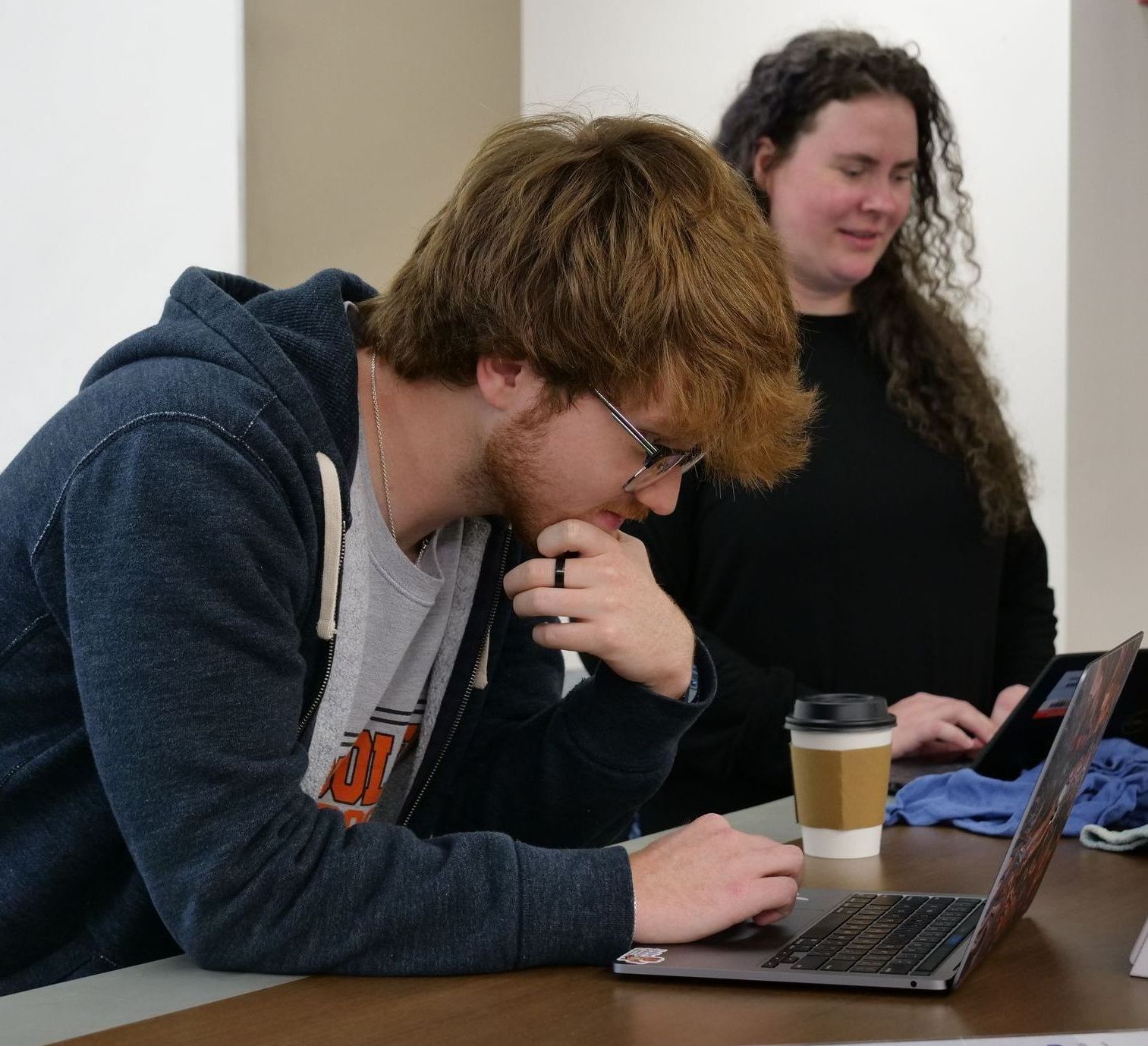 Ethan Heck and Libby Megna working on laptops.