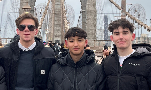 Paul Henry Bergemann, Cormac Mulcahy, and Jacob Woods standing on a bridge in New York City.