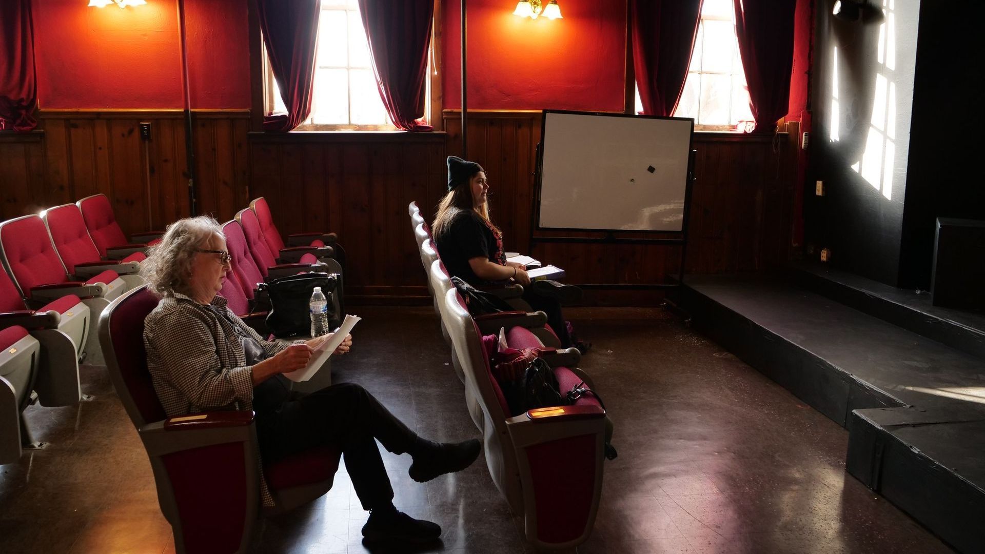 Mayla McKeehan and Tia Cobb sit in the audience watching rehearsal.