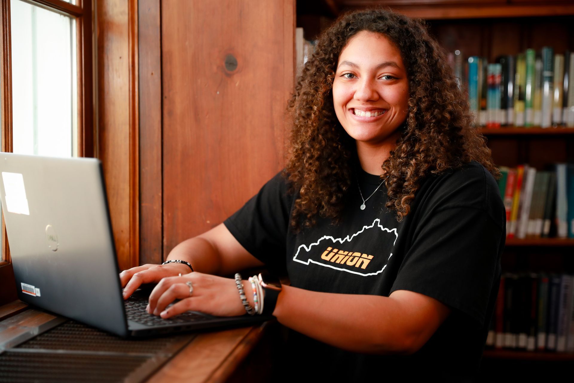 Raigan King working on her laptop in Union's library.