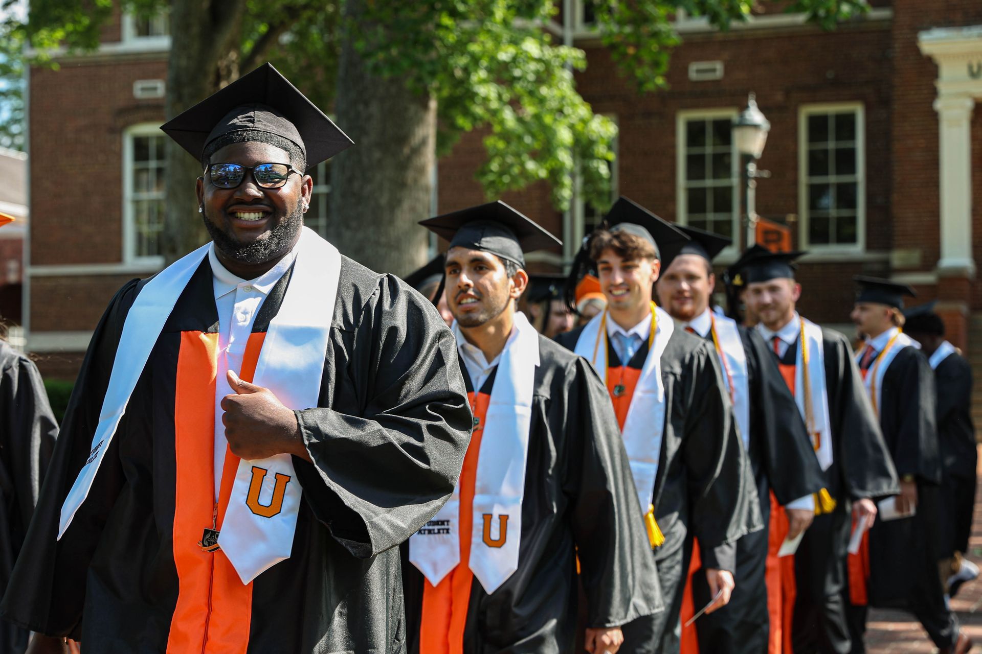 photo of students in their cap and gown walking in the processional