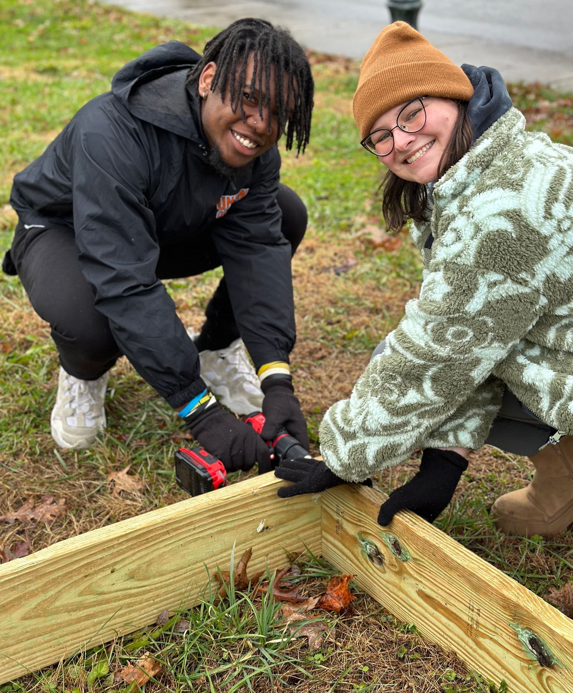 Malik McCalpine and Maggie Heinrich building a raised garden bed.