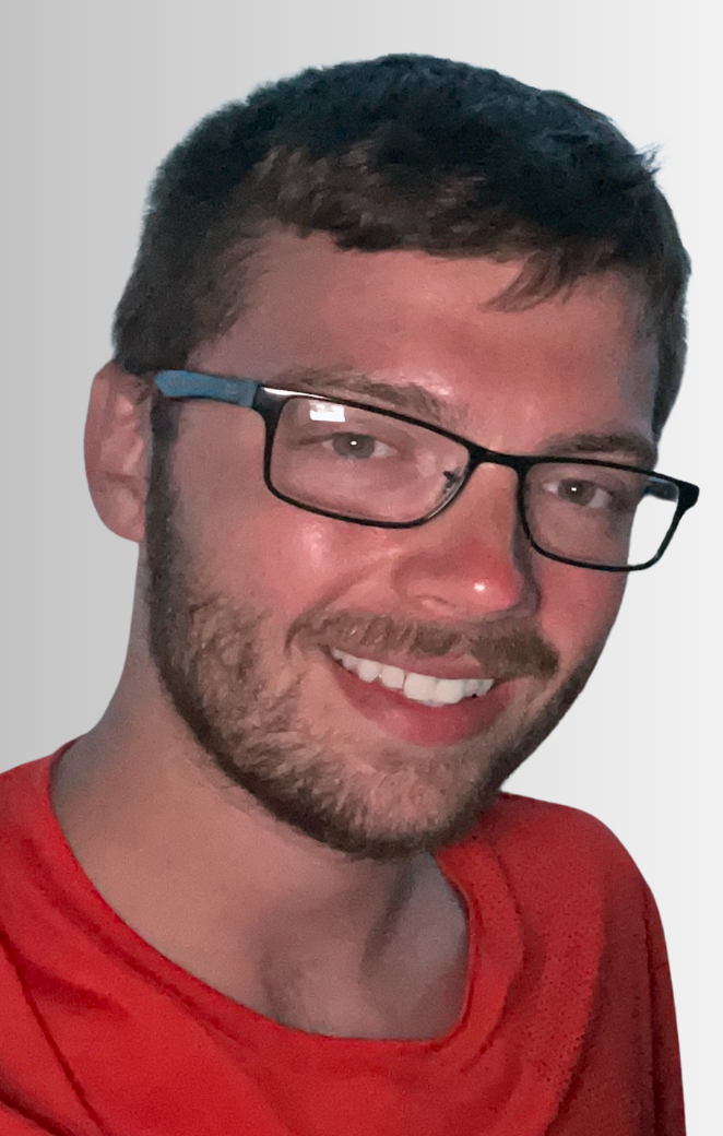 A headshot of Tyler Saylor wearing a red shirt. 