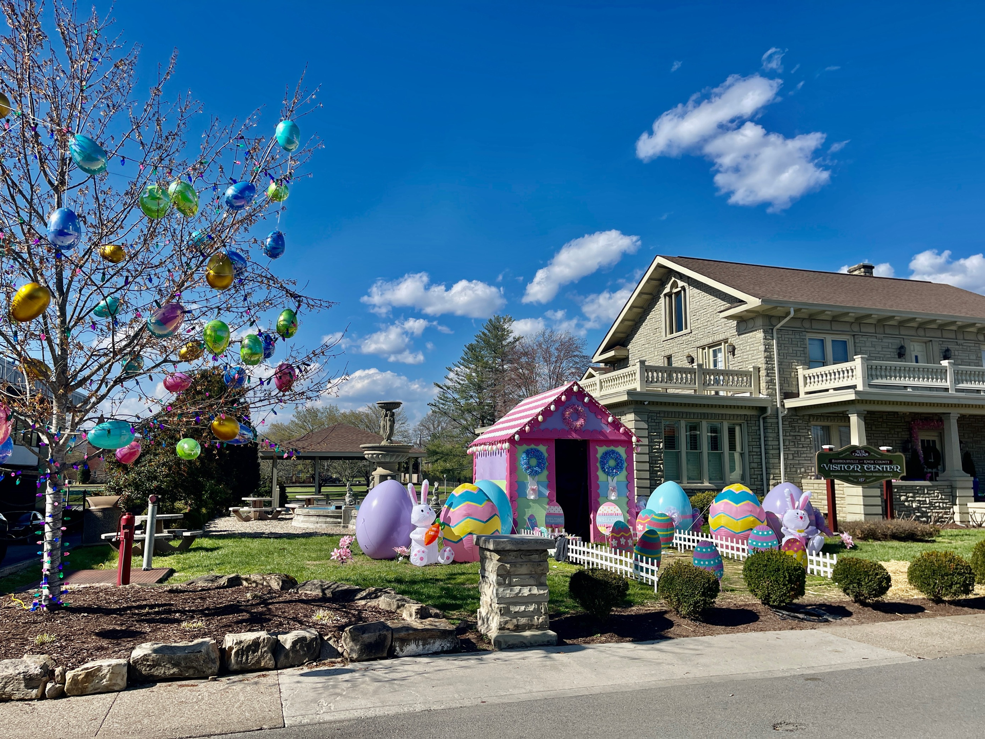 Easter decorations consisting of eggs, bunnies, and a pink shed displayed on the lawn of Barbourville's Tourism Center.