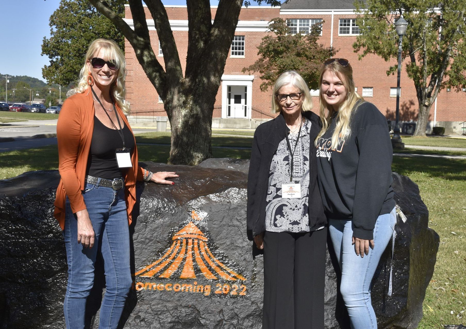 Frances, Peg, and Allie standing in front of the Spirit Rock on Union's campus.