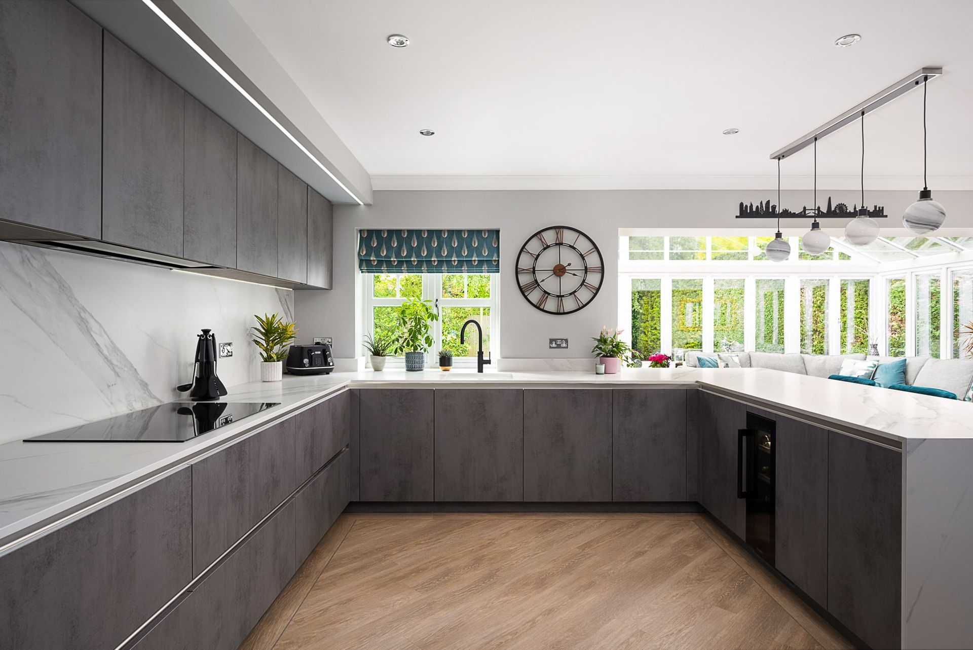 Harvey contemporary kitchen with grey, handleless units and teal furnishings. Designed by exact Kitchens in Wokingham.